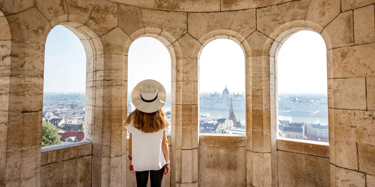 Traveller enjoying scenic Budapest city views from a historic stone terrace